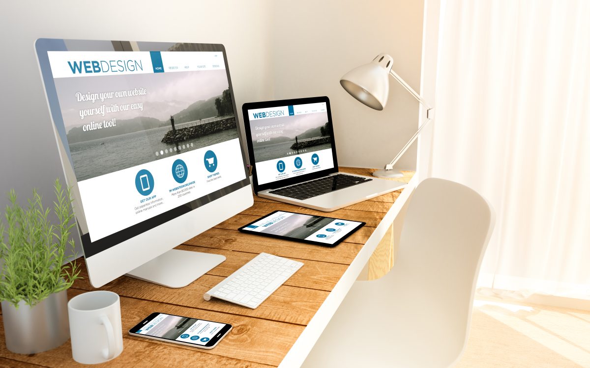 En ljus arbetsplats med skärm, laptop, surfplatta och mobil som alla visar samma responsiva webbplats
